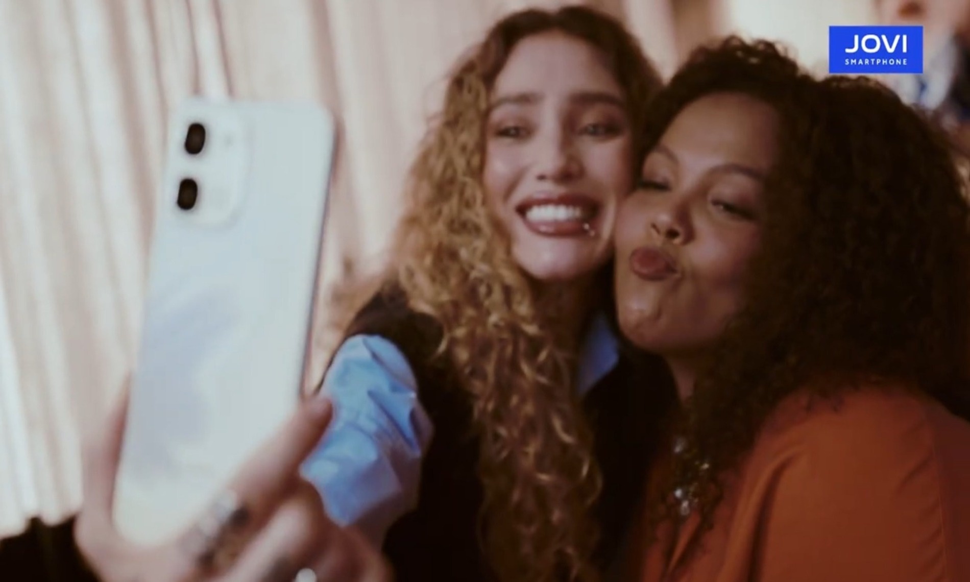 Duas mulheres tirando uma selfie com o smartphone JOVI Y31, destacando a qualidade da câmera para registrar momentos do dia a dia.