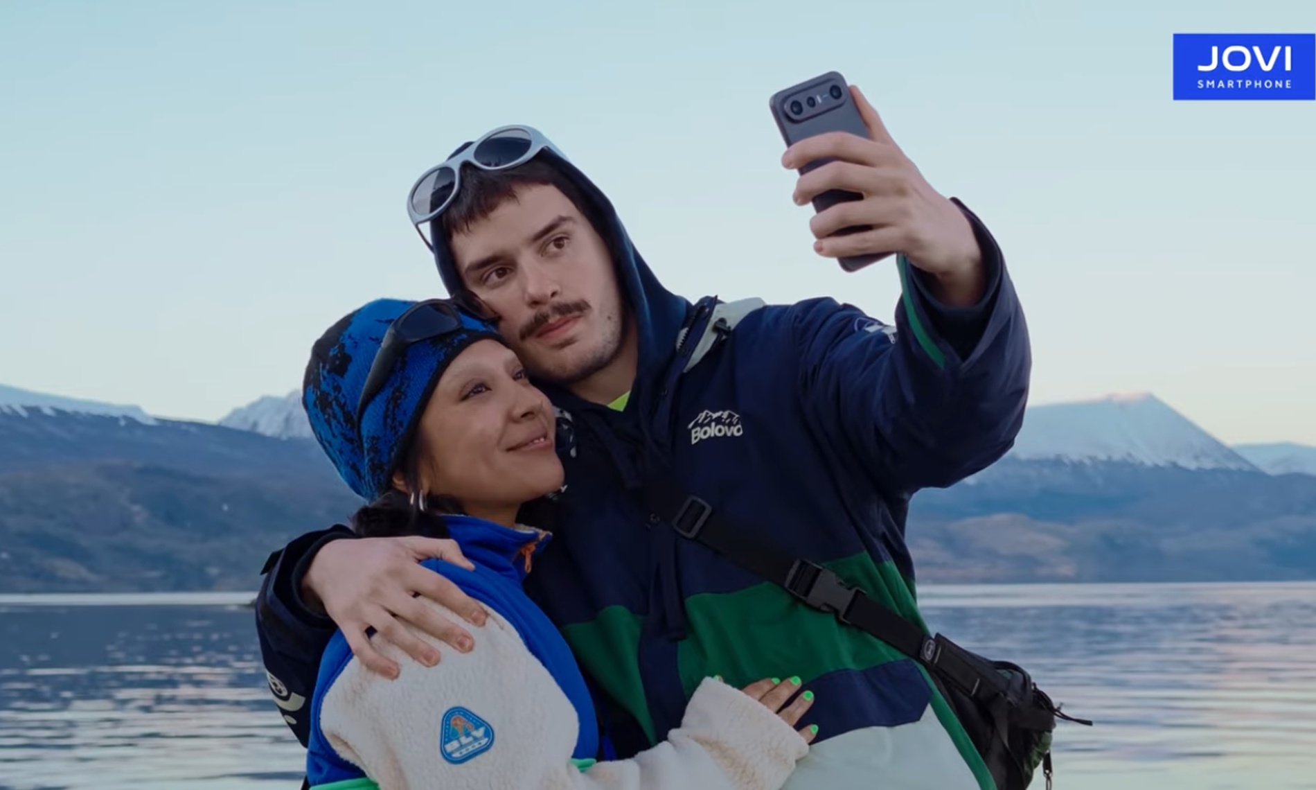JOVI X300 Ultra sendo usado para selfie durante viagem em cenário de montanhas e lago, em campanha da JOVI com a BOLOVO.